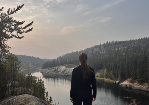 Woman standing at viewpoint during a hike at Cameron Falls, Yellowknife