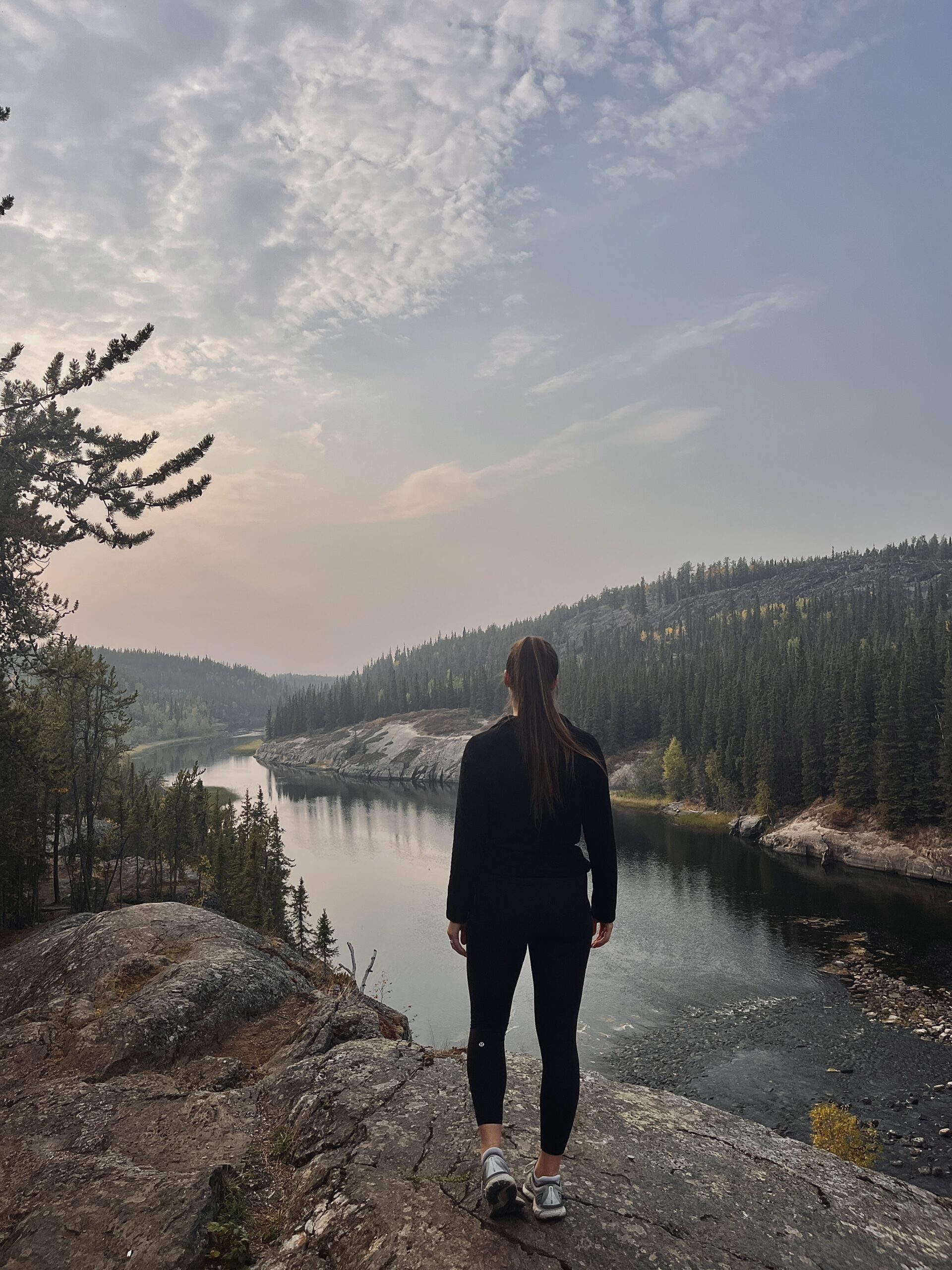 Woman standing at viewpoint during a hike at Cameron Falls, Yellowknife